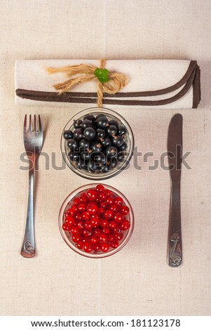 restaurant served red and black currants in a glass with green leaves