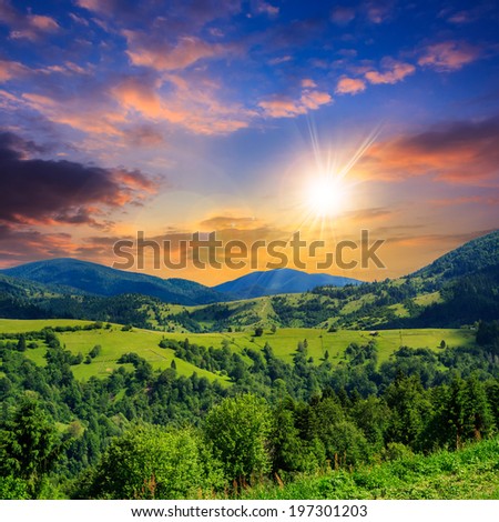 summer landscape. village on the hillside. forest on the mountain light fall on clearing on mountains at sunset