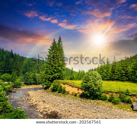 wild river flowing between green mountain forests at sunset with rainbow