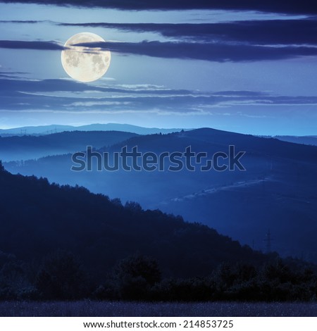 cold morning fog before sunrise in the mountains at night in full moon light