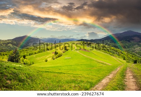 collage landscape. fence near the meadow path on the hillside with rainbow. village near forest in morning mountains