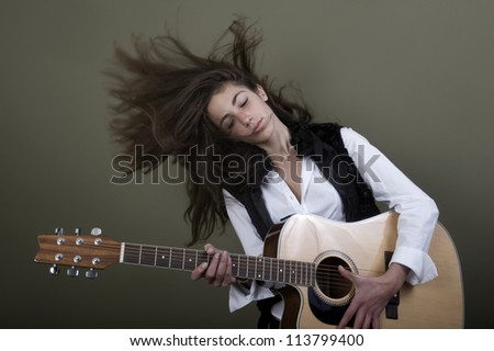 Teenage girl playing the guitar Teenage girl playing the guitar like a rock star, wearing white shirt and a black waistcoat