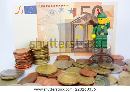 Venice, Italy - October 23, 2014: Robin Hood (as Lego figure) standing on  50 euro bill and European Euro coins, October 23, 2014 in Venice, Italy