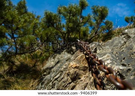 Massive metal chain fastened in the rock is used as help for tourists climbing the peak of Maly Rozsutec in the mountain of the Mala Fatra.