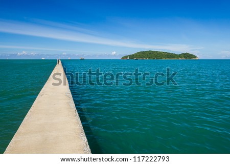 A long and small concrete pier on a sea