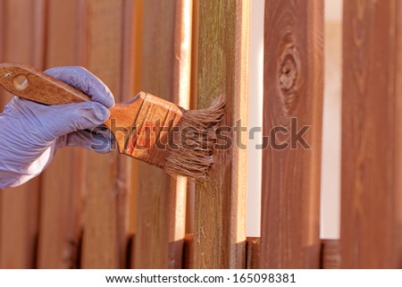 planks fence dyeing with brown paint and brush