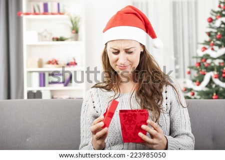 young attractive girl is sad or unhappy about christmas gift