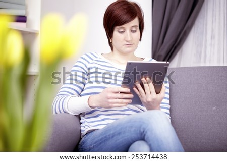 portrait of happy young girl with tablet computer shopping for easter gifts at home