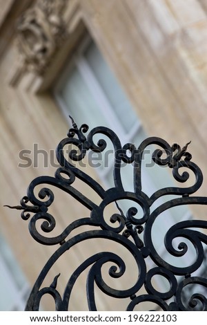 Rusty wrought iron gate in front of a French mansion