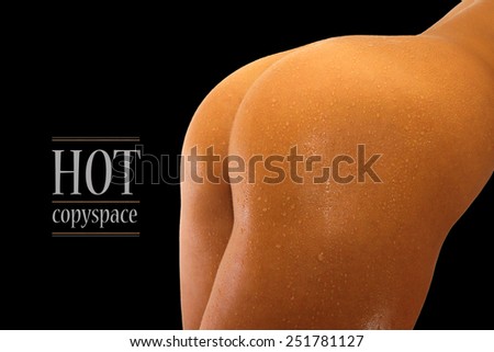 Woman's back and hips with contrast lighting and black background with copy space