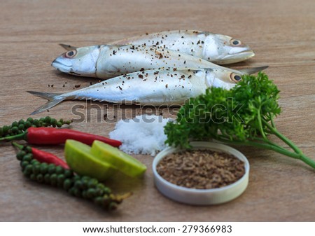 Fresh tuna with fresh pepper, salt and herbs ready for cooking on wooden background, selective focus view 2
