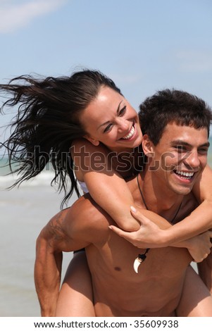 running beautiful couple on the sandy sea beach