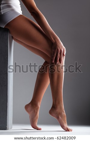 Smooth female legs on a grey background