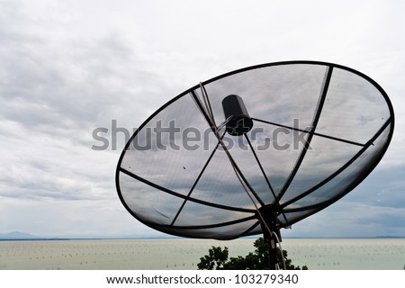 Satellite dish over the sky with clouds in the lake