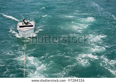 Wake of a motor boat with a small boat being towed