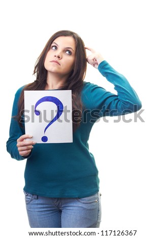 Attractive young woman in a blue shirt holding a poster with a big question mark and looking thoughtfully into the upper-left corner. Isolated on white background