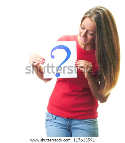 Attractive smiling young woman in a red shirt holds a poster with a big question mark, and looks at the poster. Isolated on white background