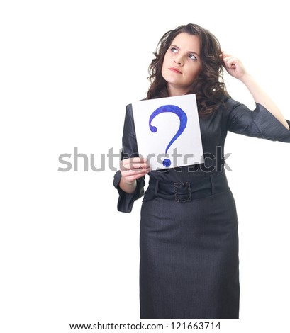 Attractive smiling young woman in a gray business dress holding a poster with a big question mark, and looks to the upper-right corner. Isolated on white background