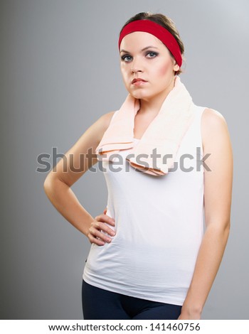 Attractive young woman in fitness wear. Isolated on a gray background