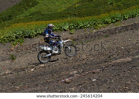 SOCHI, RUSSIA -?? AUGUST 16, 2014: Off-road motorcycle rider trains in summer mountains