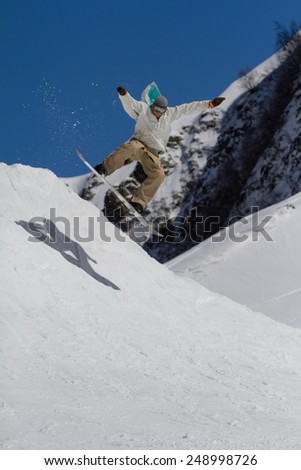 SOCHI, RUSSIA - MARCH 22, 2014: Snowboarder jumps in Snow Park,  mountain ski resort Rosa Khutor.