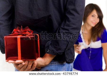 Young man hiding a gift box behind his back