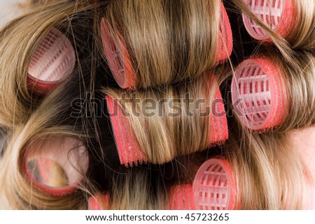 close-up of pink curlers in blond hair