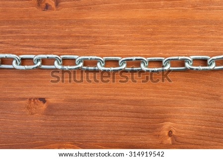 Metal chain links on wooden background
