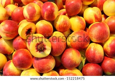 Ripe peach on pile and one is cut in half