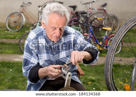 Bicycle mechanic repairing bicycle pedal in courtyard