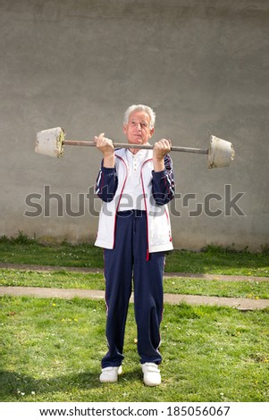 Senior man lifting homemade weights from concrete blocks