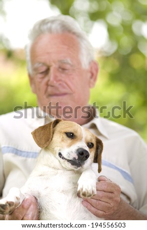 Cute dog enjoying cuddling of his elder owner