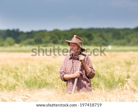 Conceived old man farmer resting in barley field after hard work