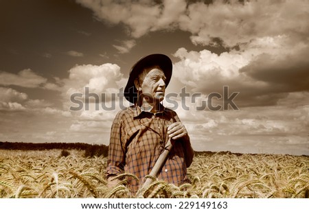 Old photo of happy senior peasant after hard work in the field