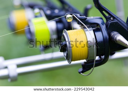 Close up of three fishing rods mounted on river coast