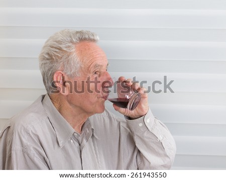 Close up of old man drinking blueberry juice