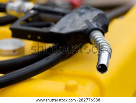 Close up of fuel nozzle on the yellow tank for agricultural purposes
