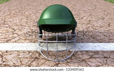 A regular green plastic cricket helmet on a cracked cricket pitch with white markings