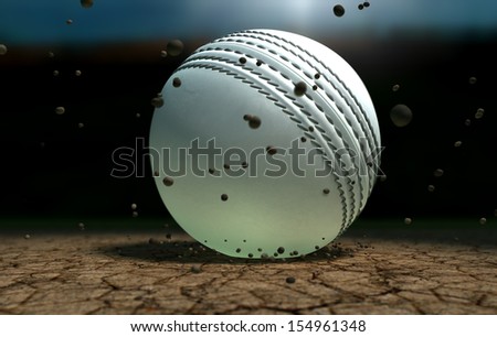 A white leather stitched cricket ball hitting a cracked cricket pitch with dirt particles emanating from the impact at night
