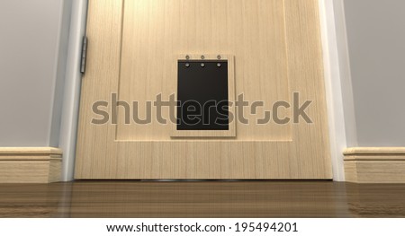 An inside view of a regular black pet flap on a light wood door surrounded by walls  and wood skirting