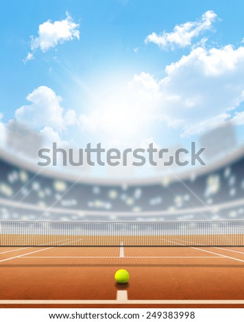 A tennis court in an arena with a marked clay surface in the daytime under a blue sky
