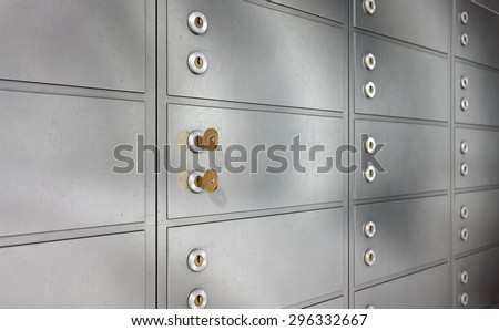 A closeup of a wall of closed metal safety deposit boxes and one with two keys inserted into it