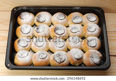 cottage cheese cakes  with jam on baking tray on  wooden table