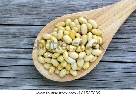 Peruvian Canary (Peruano) Beans on wooden spoon on grunge table