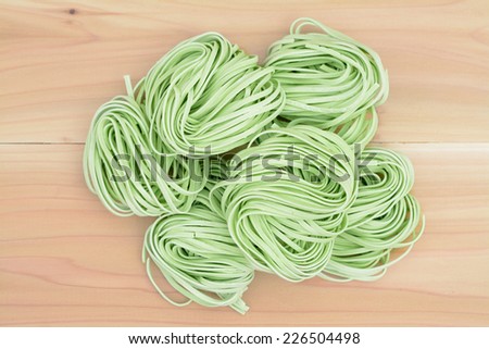bunches dried green noodle on wooden table