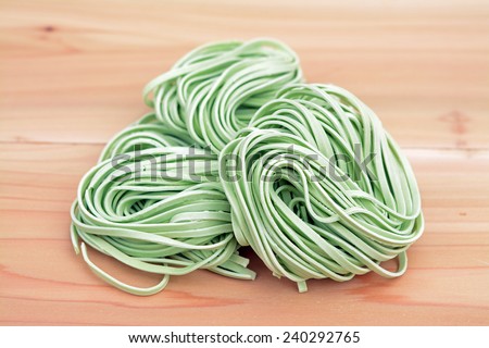 bunches dried green noodle on wooden table