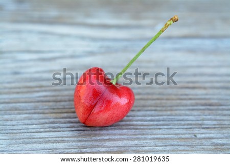 single cherry fruit on rustic wooden table