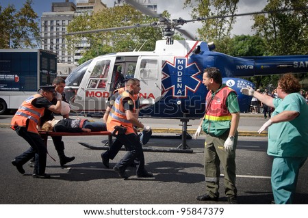 BUENOS AIRES, ARGENTINA - FEB 22: An injured woman is transported in a stretcher next to a helicopter after a train crashed at Once train station in Buenos Aires on February 22, 2012.
