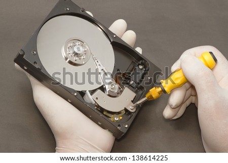 Hand with gloves repairs hard drive ,data recovery concept