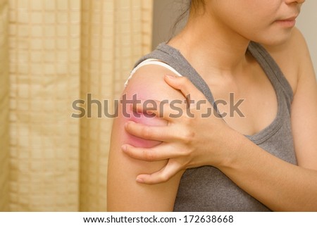 woman holding her shoulder for the pain